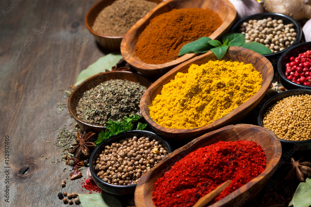 assortment of oriental spices on a wooden background, top view