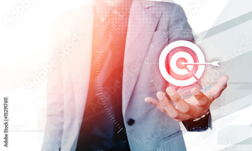 Businessman hand showing on target business concept with blank copyspace area for text or slogan, against grey background