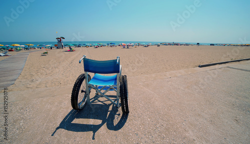 Special cast wheelchair on the sandy beach of the tourist resort