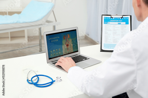 Doctor with laptop and labo...