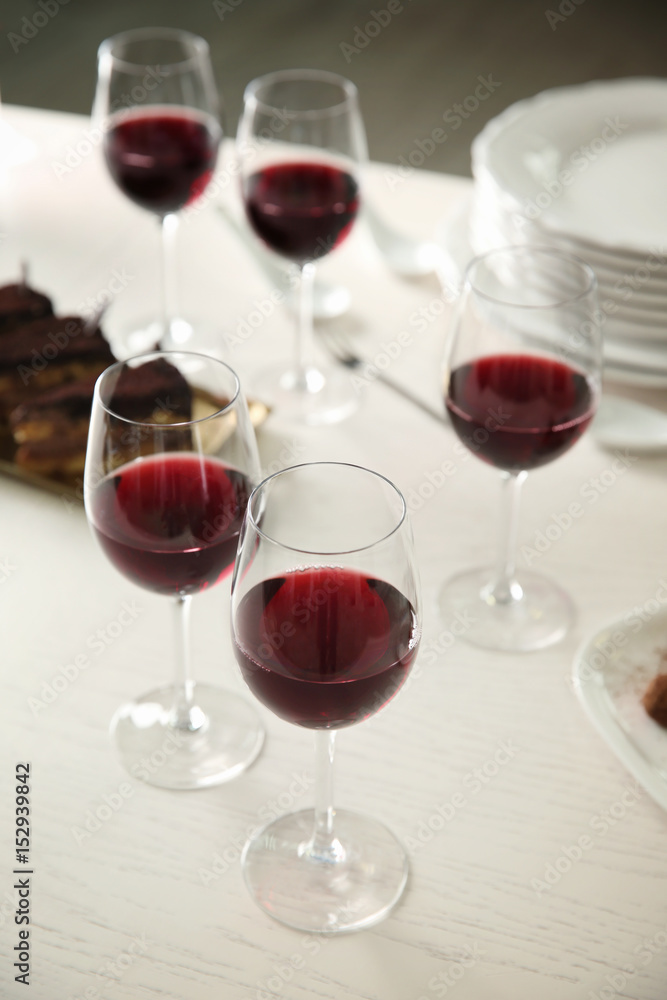 Red wine and delicious chocolate desserts on white table