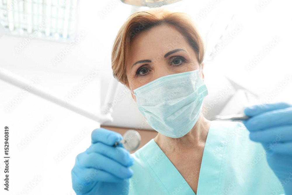Dentist with mirror and periodontal explorer in clinic Dentist with mirror and periodontal explorer in clinic