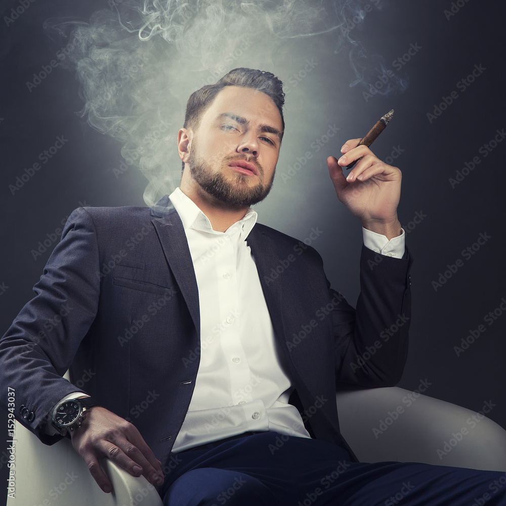 Man wearing suit and watch smoking cigar in chair. Perfect hair style and  beard Stock Photo | Adobe Stock
