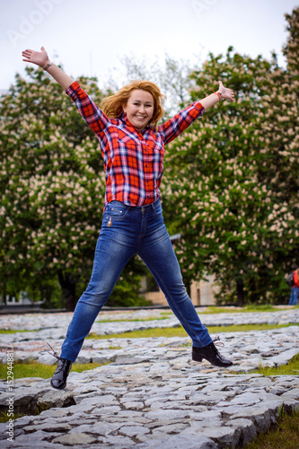 Simple american girl from next door in a plaid shirt walk in central park. Smiling and laughing have fun time