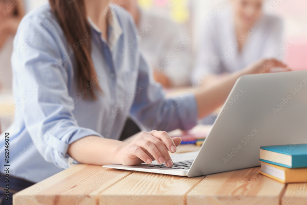 Woman sitting at table and using laptop, closeup Woman sitting at table and using laptop, closeup
