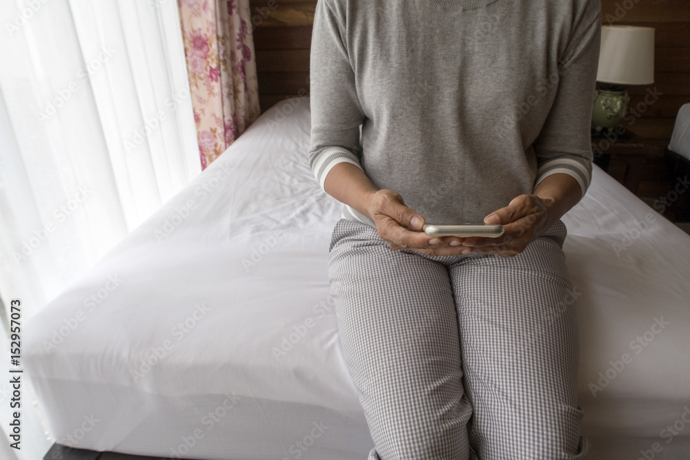 middle aged woman using smart phone in bed