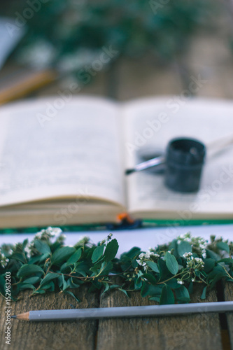 Lilac branches on a wooden background with a book. photo