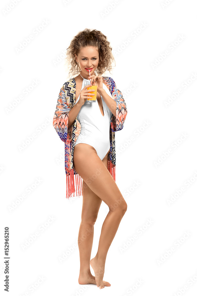 Beautiful young woman in beachwear drinking juice on white background Beautiful young woman in beachwear drinking juice on white background