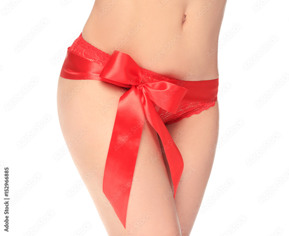 Young woman with epilated bikini zone and ribbon on white background Young woman with epilated bikini zone and ribbon on white background