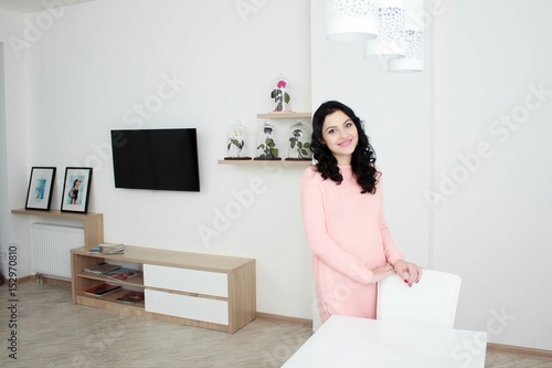 Portrait of beautiful young woman standing in modern interior