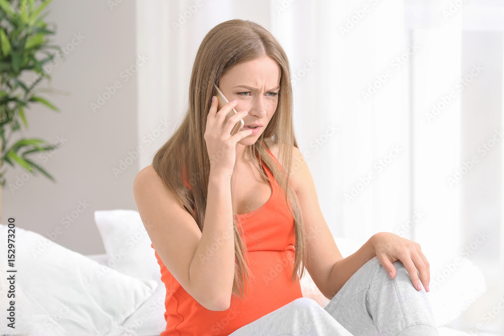 Emotional pregnant woman talking by mobile phone at home Emotional pregnant woman talking by mobile phone at home