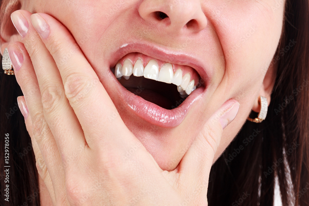 Closeup of woman in strong toothache pain with hands over face. Dental health and care concept. Closeup of woman in strong toothache pain with hands over face. Dental health and care concept.