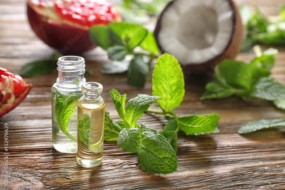 Beautiful composition with perfume bottles and mint on wooden background Beautiful composition with perfume bottles and mint on wooden background