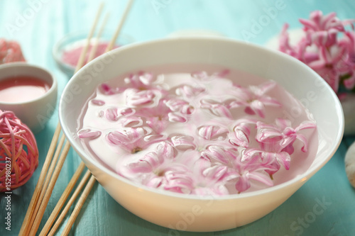 Beautiful spa composition with flower petals on water in bowl, closeup