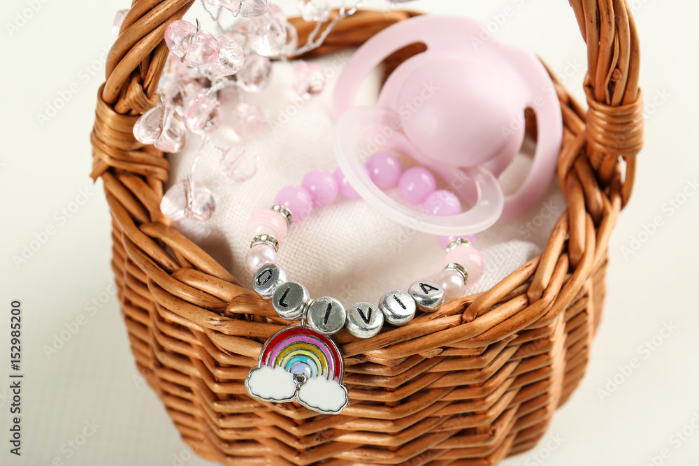 Bracelet with baby name Olivia in basket on white background