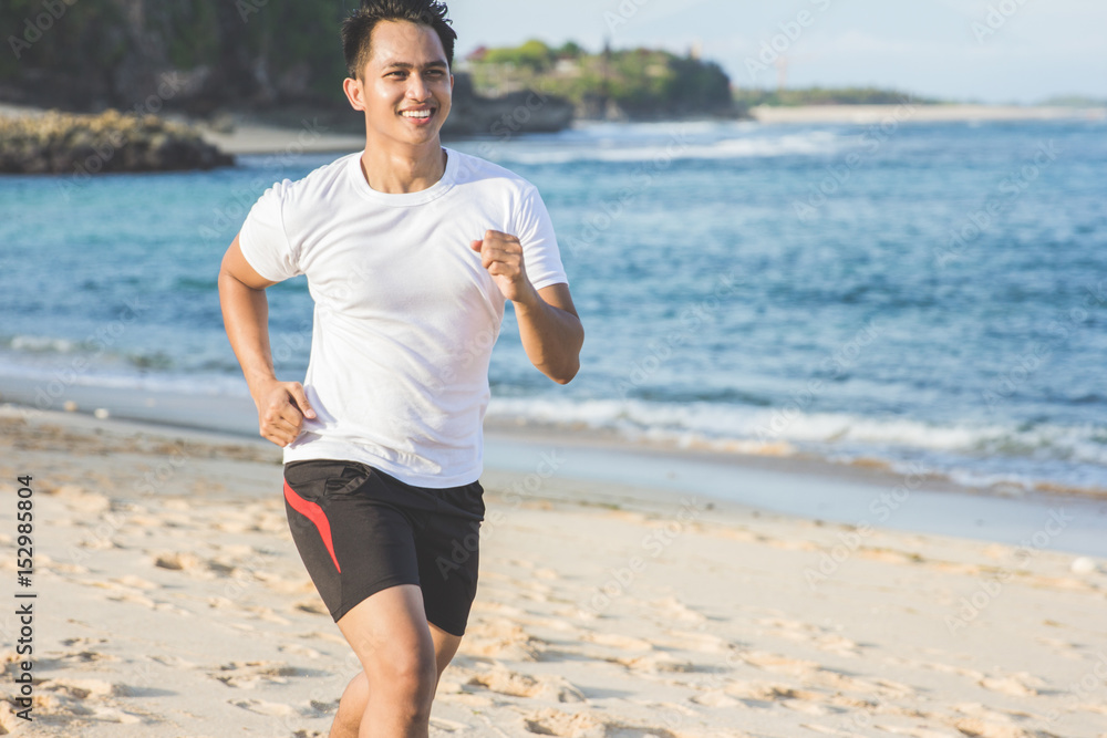 Handsome man running on the beach Handsome man running on the beach