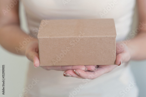 Woman holding a gift box in a gesture of giving. photo