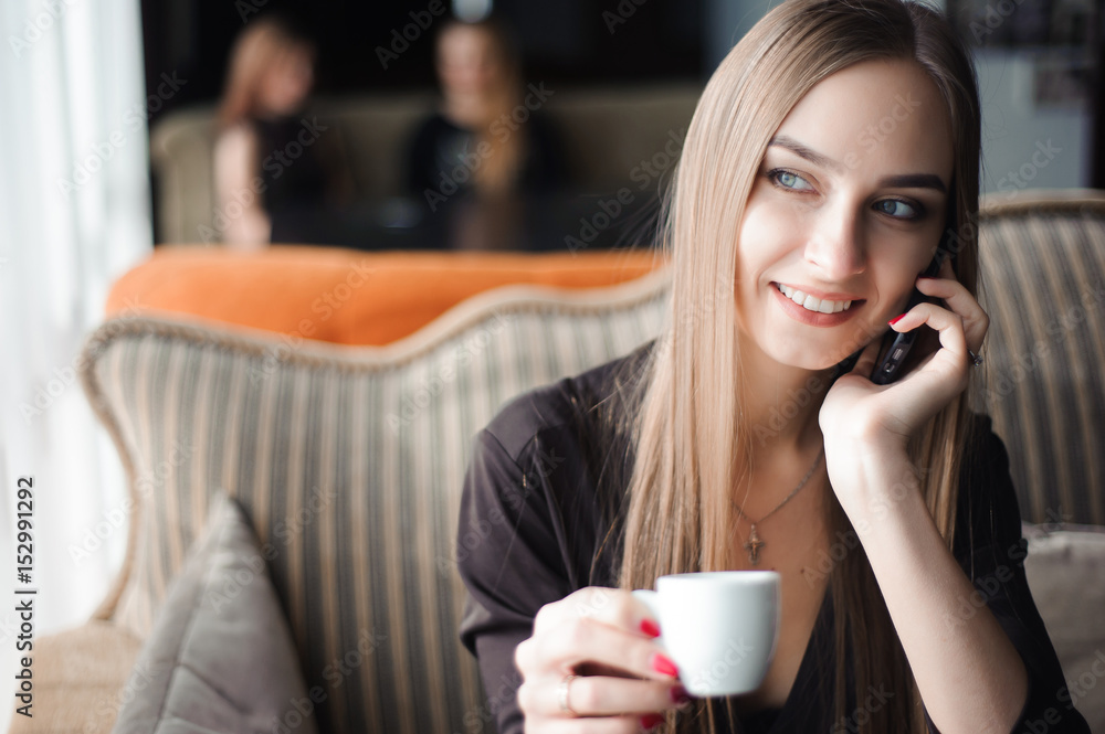 a woman with cute smile having mobile phone conversation while resting after work day in cafe a woman with cute smile having mobile phone conversation while resting after work day in cafe