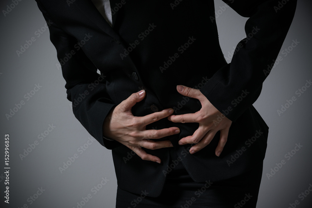 Obraz premium 腹が痛いビジネスウーマン