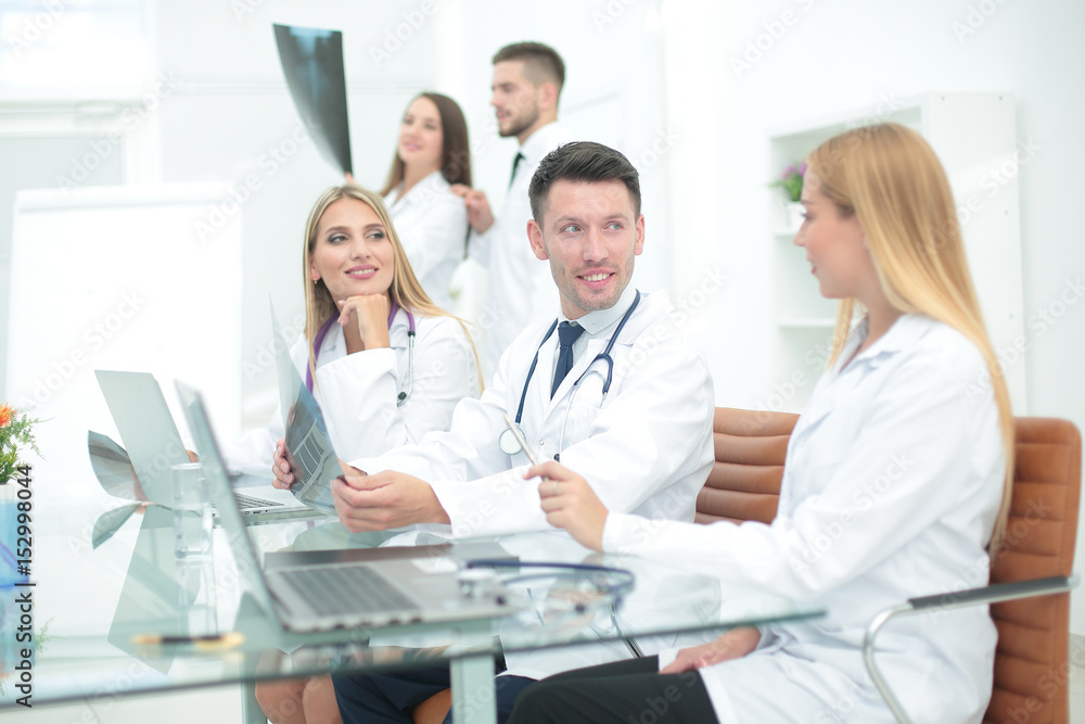 Smiling doctors working at office desk and smiling, medical office Smiling doctors working at office desk and smiling, medical office