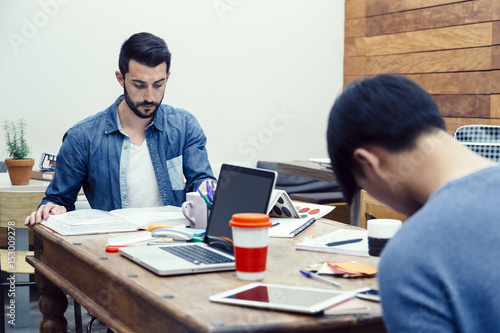 Two young entrepreneurs preparing their new business project in a modern coworking espace