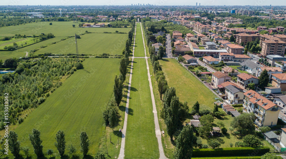 Nuovo Skyline di Milano visto dall’hinterland milanese, vista aerea, viale alberato, percorso ciclo pedonale. Varedo, Monza Brianza, Lombardia. Italia