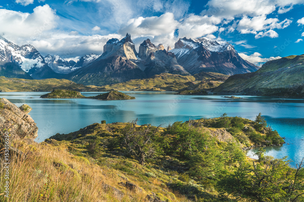Blue lake on a snowy mountains background and cloudy sky Torres del paine - obrazy, fototapety, plakaty 