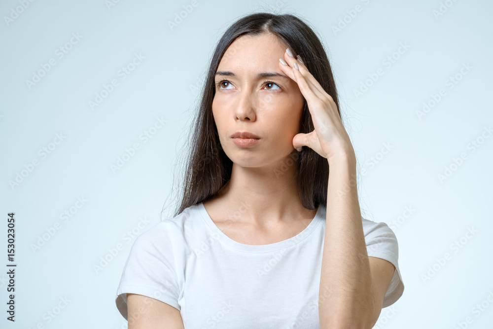 Young pretty brunette girl touching her head Young pretty brunette girl touching her head