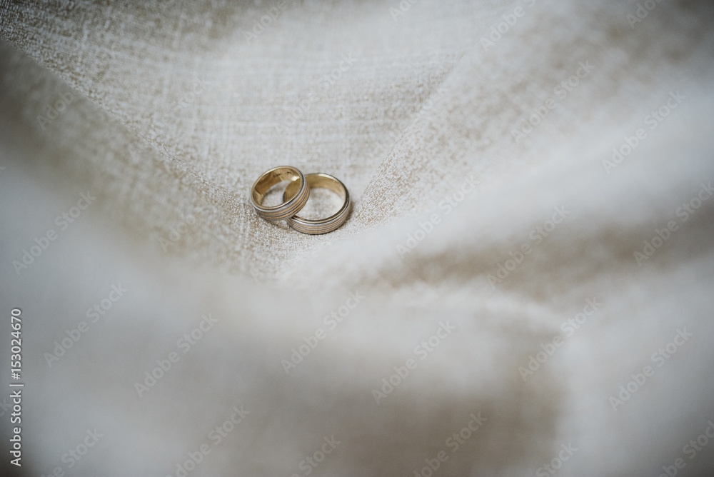 Wedding rings on fabric light brown background Wedding rings on fabric light brown background