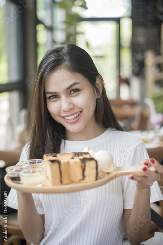 Beautiful girl holding dessert in coffee shop