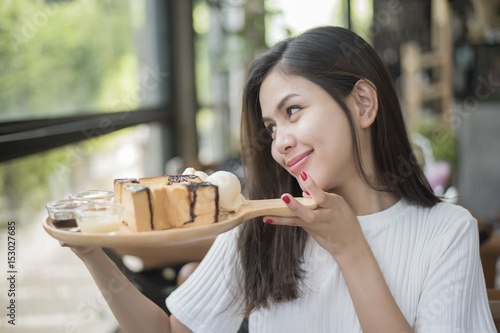 Beautiful girl holding dessert in coffee shop