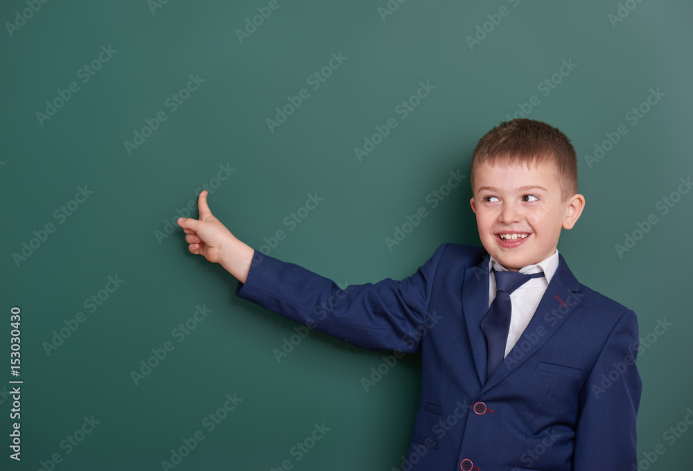 school boy point the finger near blank chalkboard background, dressed in classic black suit, group pupil, education concept school boy point the finger near blank chalkboard background, dressed in classic black suit, group pupil, education concept