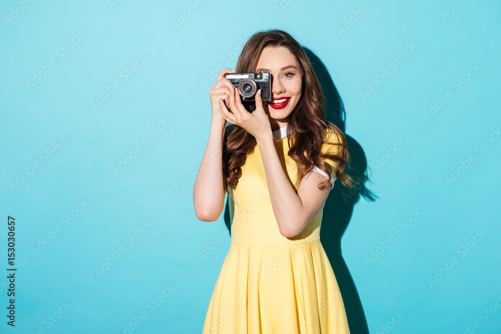 Pretty girl in dress taking photo on a retro camera Pretty girl in dress taking photo on a retro camera
