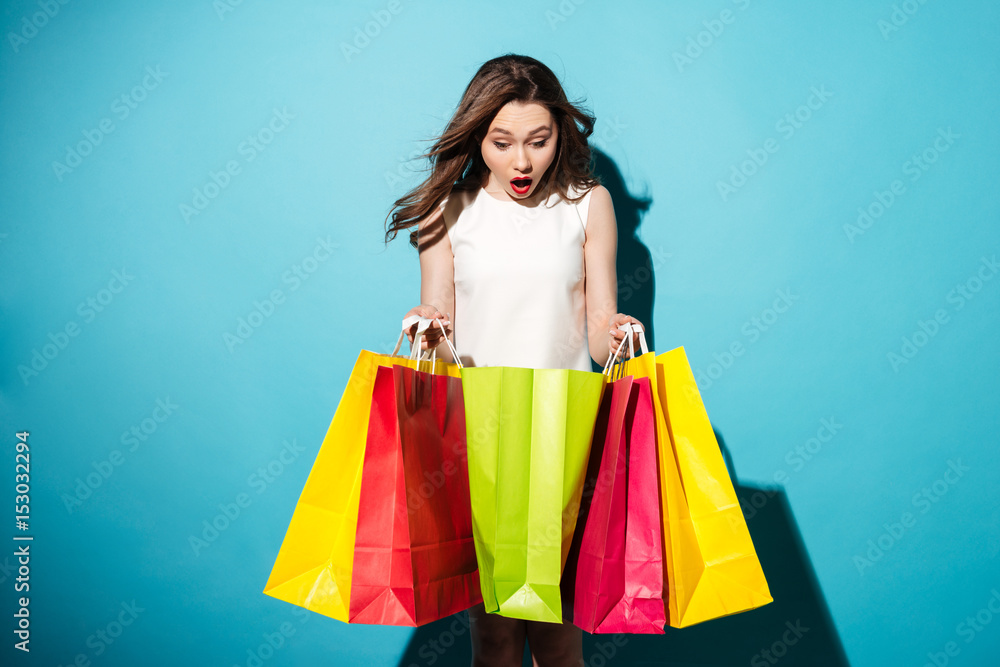 Portrait of a pretty young woman shopaholic with colorful bags
