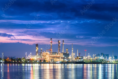 Twilight scene of oil refinery plant and cargo shipping.