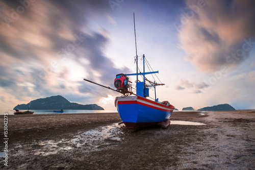 Fishing boat, waves clouds and blue sky, nature background.