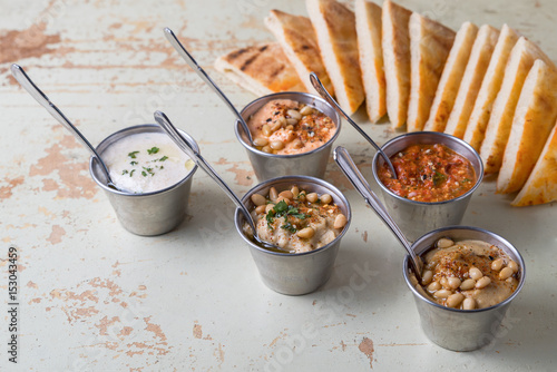 Set of appetizers: hummus, muhammara, tirokafteri, Greek cacik photo