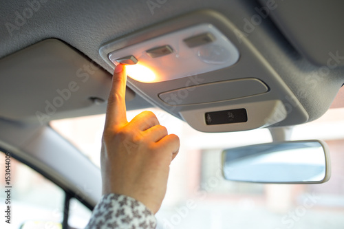 Man turning on the light in the car in his car, close-up