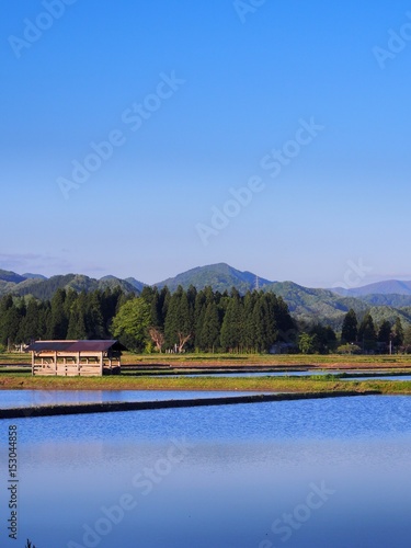 小屋のある風景 春の田植え前の田んぼ 青空