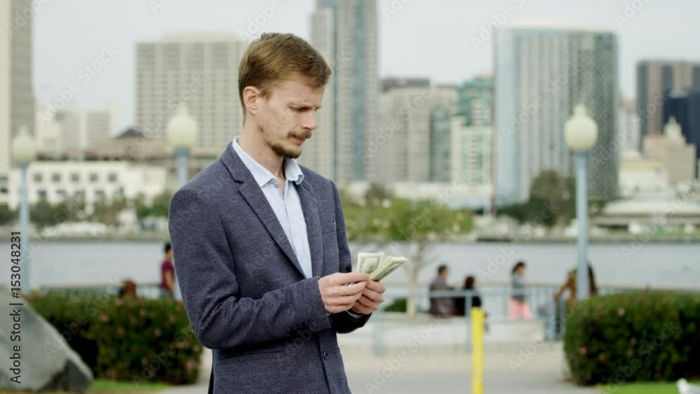 Bearded businessman is counting his money on a street Bearded businessman is counting his money on a street