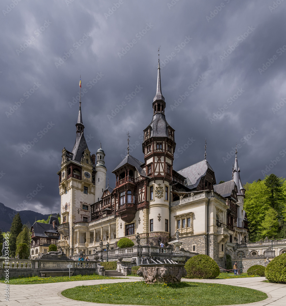 The magnificent Peles Castle a Neo-Renaissance castle in the Carpathian Mountains, near Sinaia, in Prahova County, Romania, against a dramatic sky