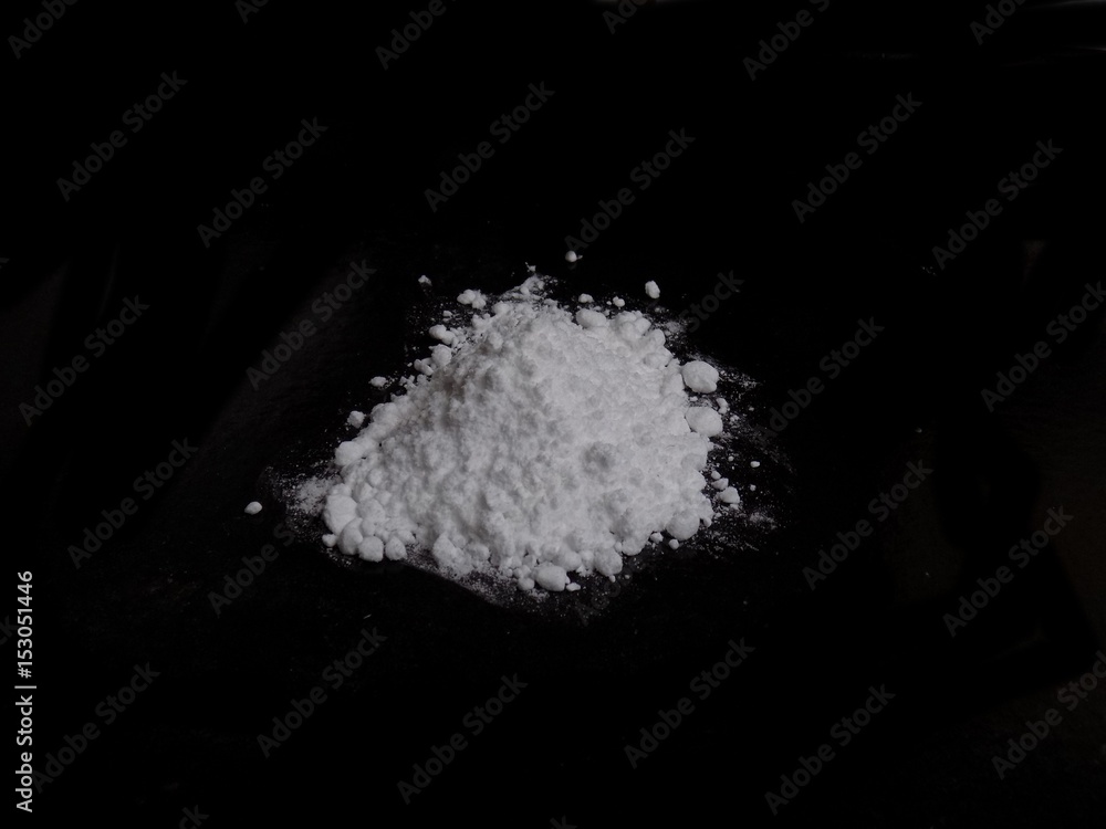 Cocaine drug powder pile on black background
