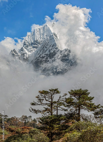 Mistly view the peaks Kantega (6783 m) and Tangtse (6770 m) from Khumjung on a sunny day - Nepal, Himalayas photo