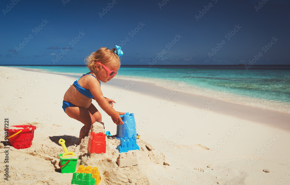 cute little girl playing with sand on beach cute little girl playing with sand on beach