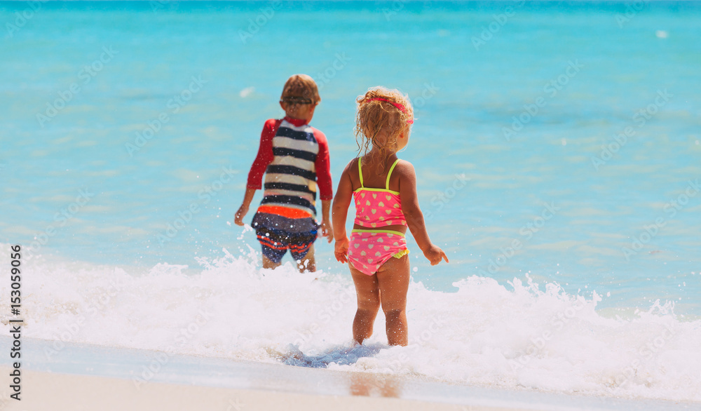 little boy and girl go swim on beach little boy and girl go swim on beach