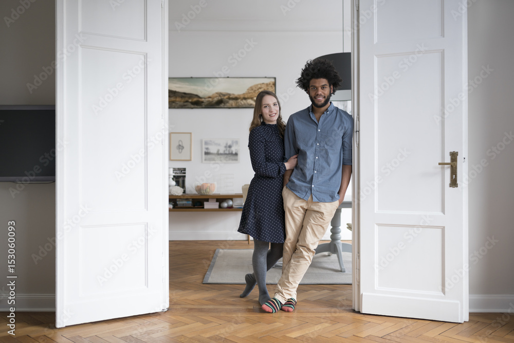 Smiling couple at home standing in door frame Smiling couple at home standing in door frame