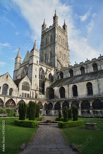 Gloucester Cathedrale in Enhland. Green garden, tower and blue sky.