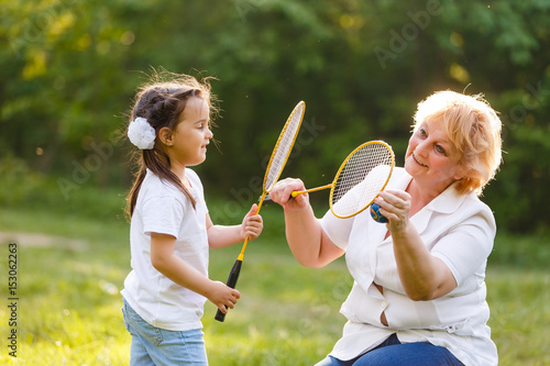 Mother and daughter playing tennis, portrait photo