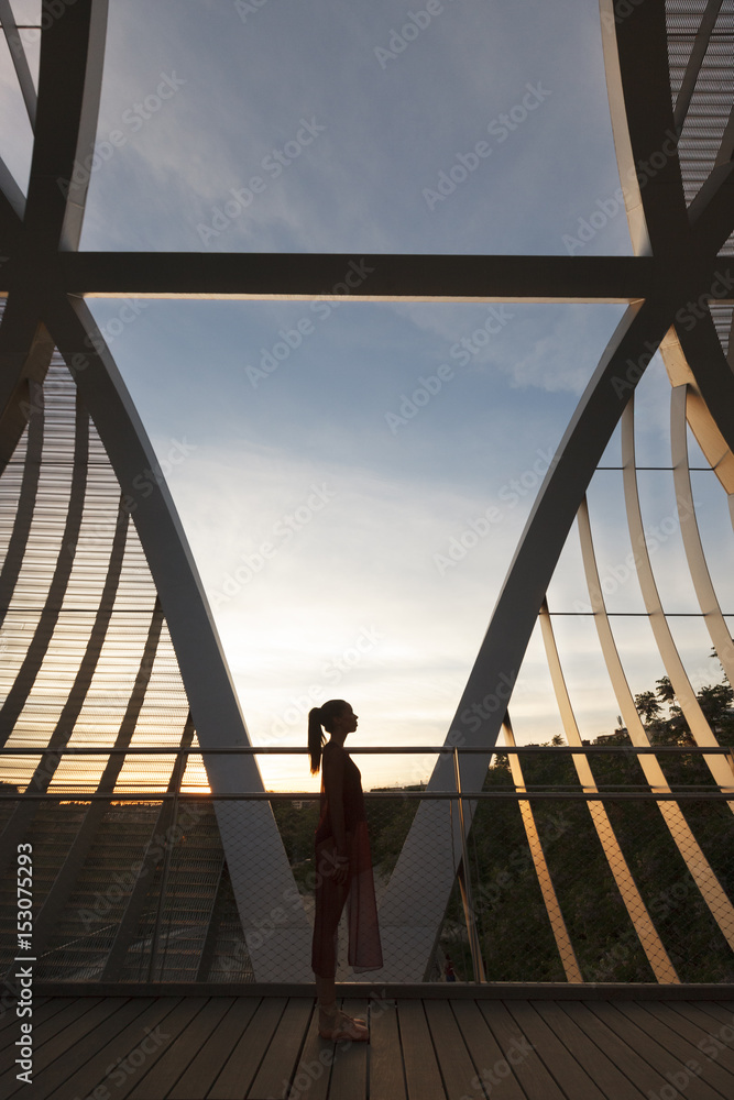 woman dancer isolated on a modern bridge with metal structure woman dancer isolated on a modern bridge with metal structure