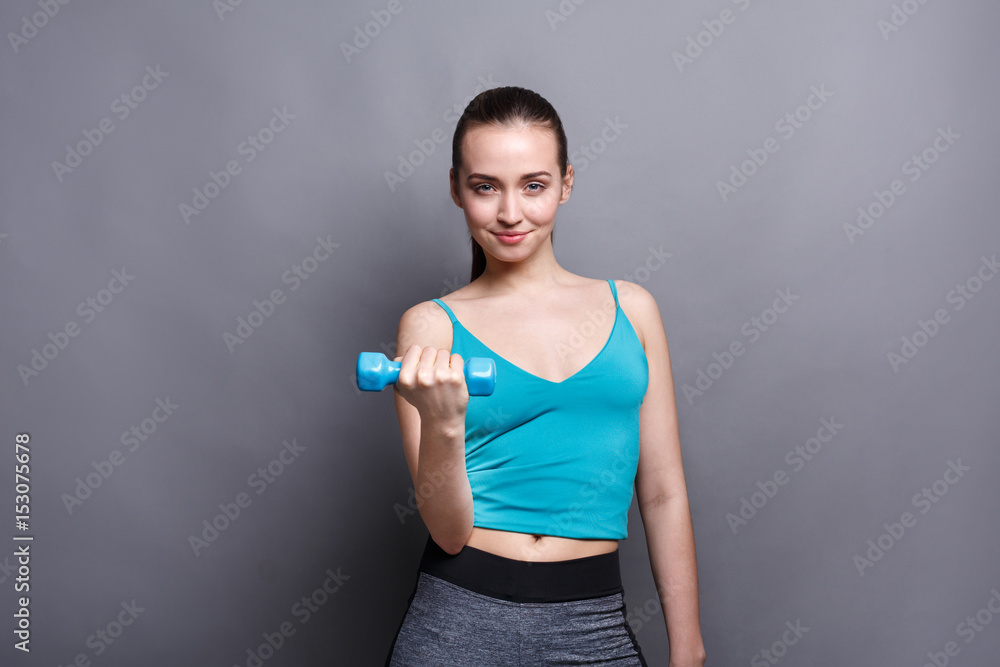 Fitness model woman with dumbbells at studio background Fitness model woman with dumbbells at studio background